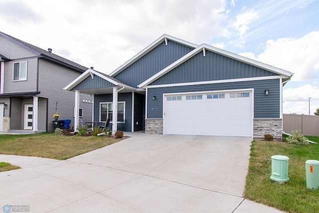 craftsman house with a front yard and a garage