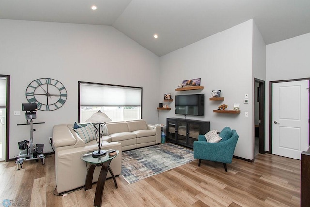 living room featuring light wood-type flooring and high vaulted ceiling