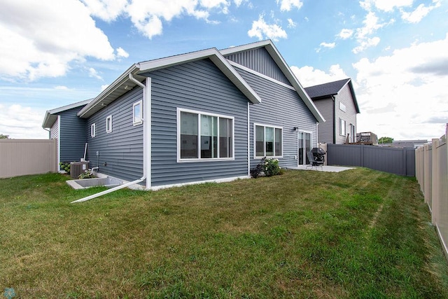 rear view of property featuring central AC unit, a lawn, and a patio area