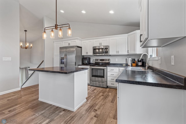 kitchen featuring hanging light fixtures, sink, white cabinetry, appliances with stainless steel finishes, and a center island