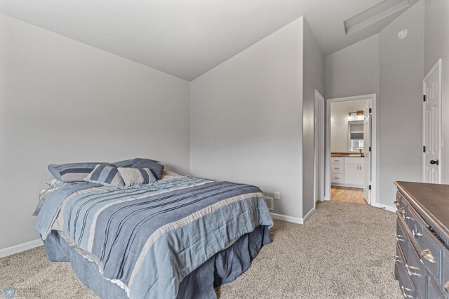 bedroom with light carpet, ensuite bath, and high vaulted ceiling