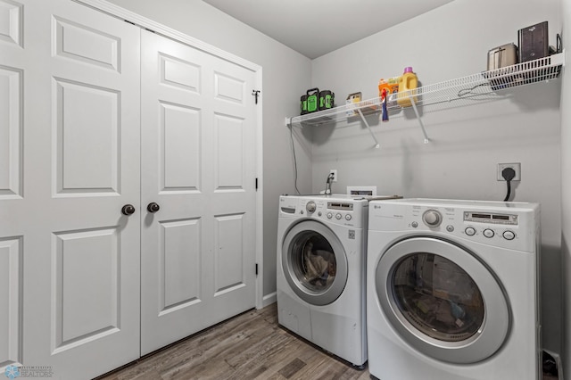 laundry room with wood-type flooring and separate washer and dryer