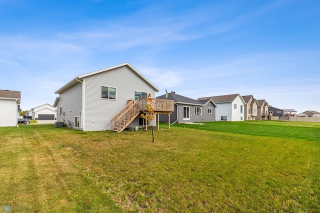 rear view of property featuring a deck, a yard, and central AC