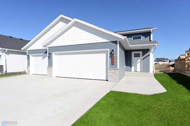 craftsman inspired home featuring a garage and a front lawn