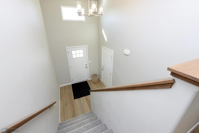 staircase featuring hardwood / wood-style flooring and a chandelier