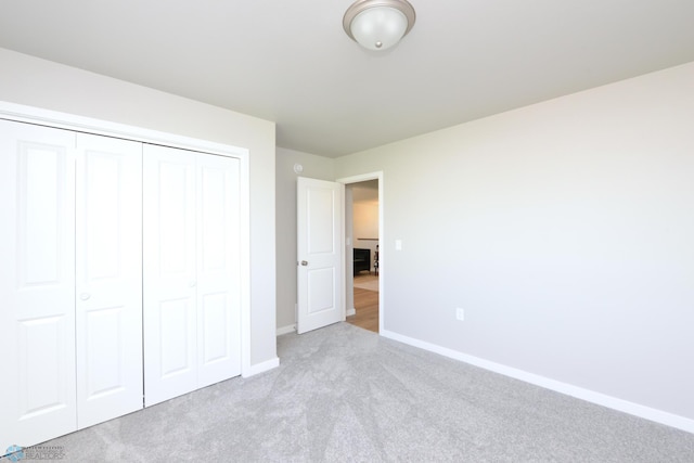 unfurnished bedroom featuring light colored carpet and a closet