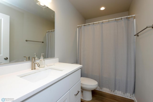 bathroom featuring wood-type flooring, vanity, toilet, and a shower with shower curtain