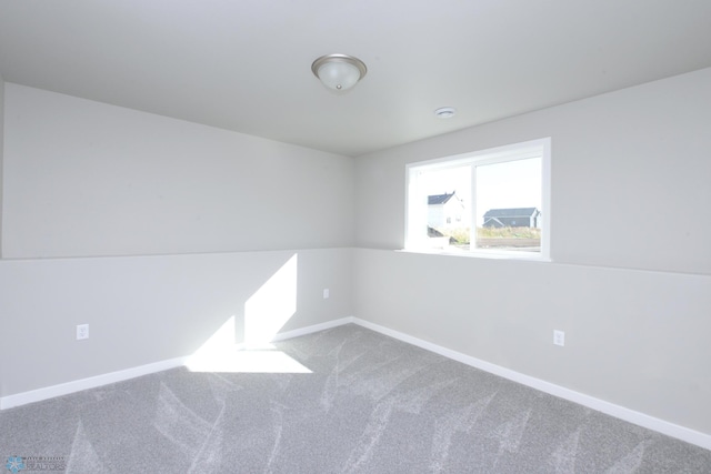 spare room with carpet and lofted ceiling