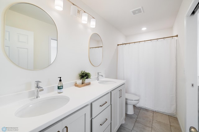 bathroom with tile patterned flooring, curtained shower, vanity, and toilet