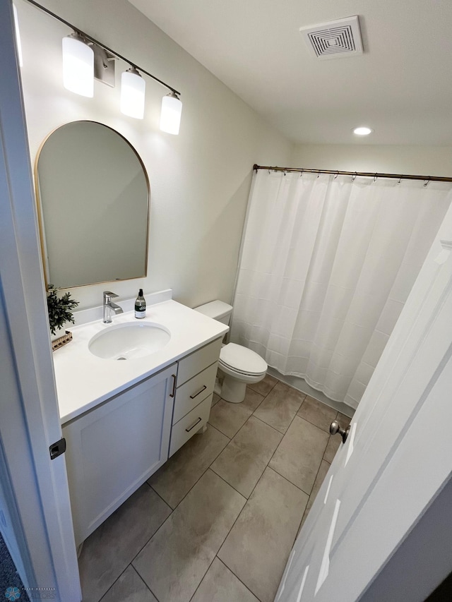 bathroom featuring tile patterned floors, curtained shower, vanity, and toilet