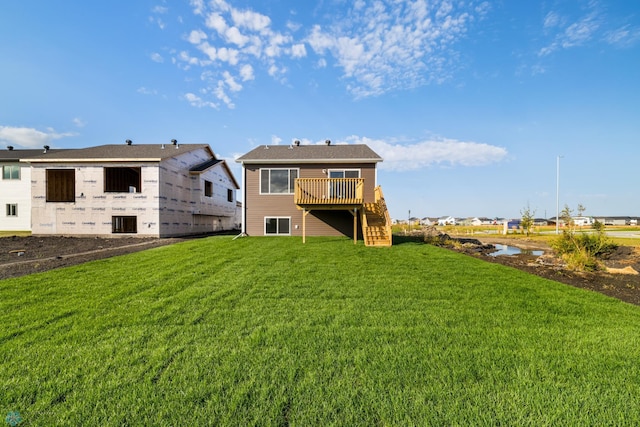 back of property with a yard and a wooden deck