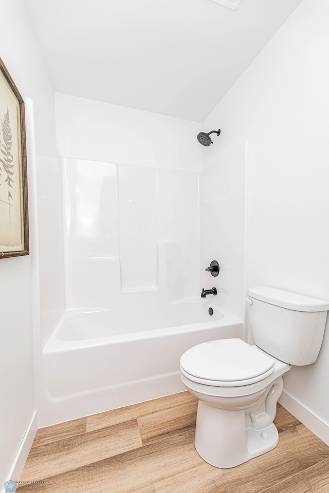 bathroom featuring hardwood / wood-style flooring, toilet, and shower / bathtub combination