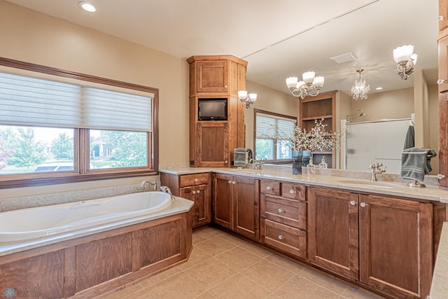 bathroom featuring an inviting chandelier, vanity, plus walk in shower, and a wealth of natural light