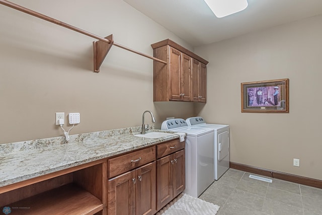 washroom featuring cabinets, independent washer and dryer, light tile patterned floors, and sink