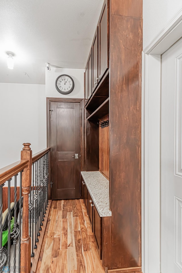 mudroom with a textured ceiling and light hardwood / wood-style flooring