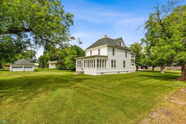 rear view of property featuring a yard and a sunroom