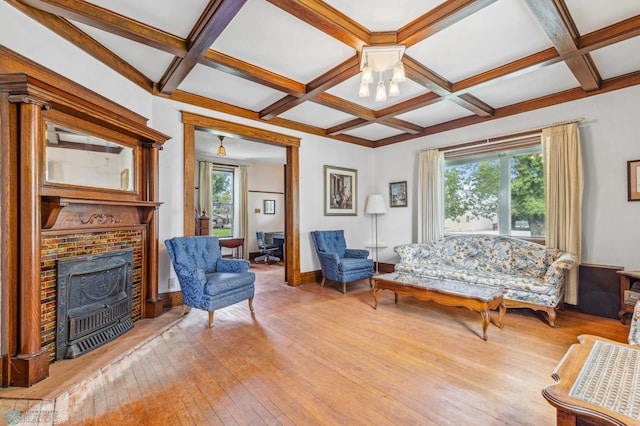 living room with light hardwood / wood-style flooring, a wealth of natural light, coffered ceiling, and a fireplace