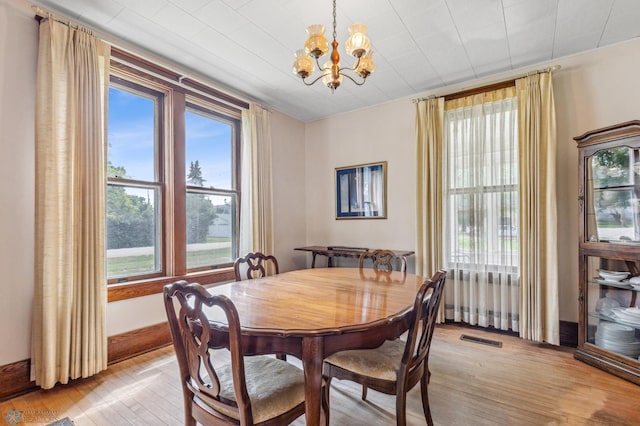 dining area with a notable chandelier and light wood-type flooring