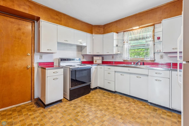 kitchen with white cabinets, sink, and electric range