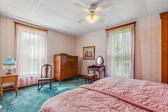 bedroom with ceiling fan, carpet flooring, and a paneled ceiling