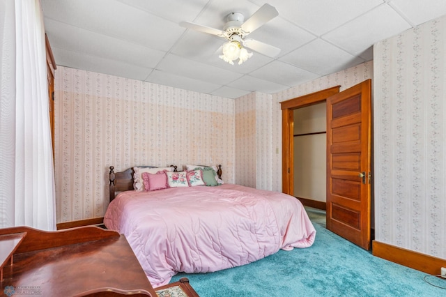 bedroom with a drop ceiling, ceiling fan, and carpet floors