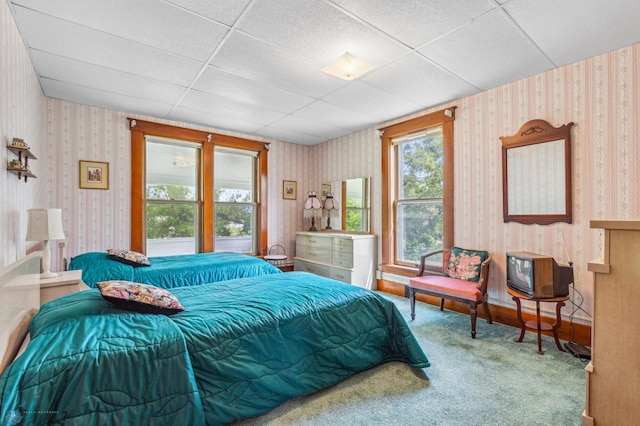 carpeted bedroom with a drop ceiling