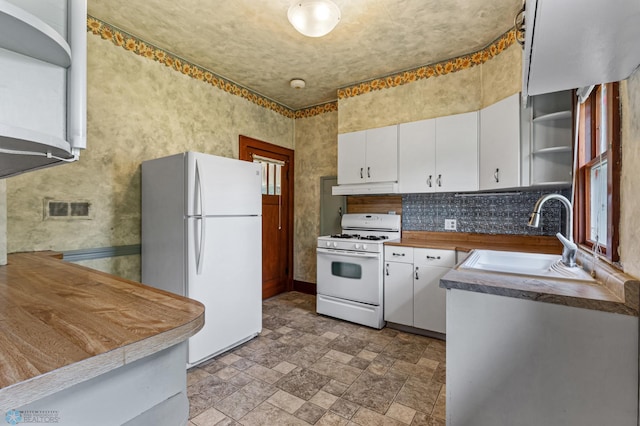 kitchen featuring white appliances, sink, tasteful backsplash, and white cabinets