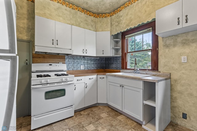 kitchen featuring white cabinetry, white gas stove, and sink