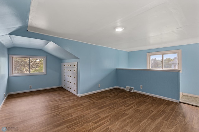 additional living space with lofted ceiling and dark hardwood / wood-style flooring