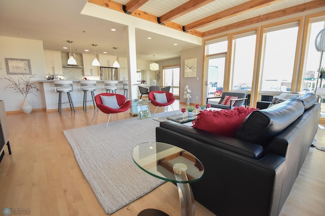 living room with light hardwood / wood-style flooring, beamed ceiling, and wooden ceiling