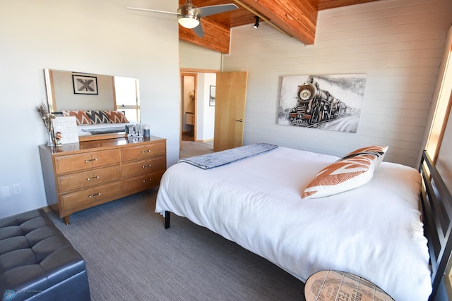 carpeted bedroom featuring beamed ceiling and ceiling fan