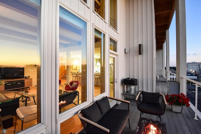 balcony at dusk featuring a grill