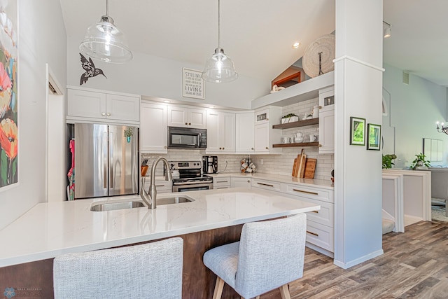 kitchen featuring white cabinets, stainless steel appliances, and high vaulted ceiling