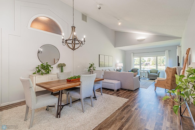 dining space featuring an inviting chandelier, dark wood-type flooring, and high vaulted ceiling