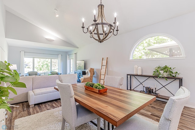 dining area with an inviting chandelier, vaulted ceiling, plenty of natural light, and hardwood / wood-style floors