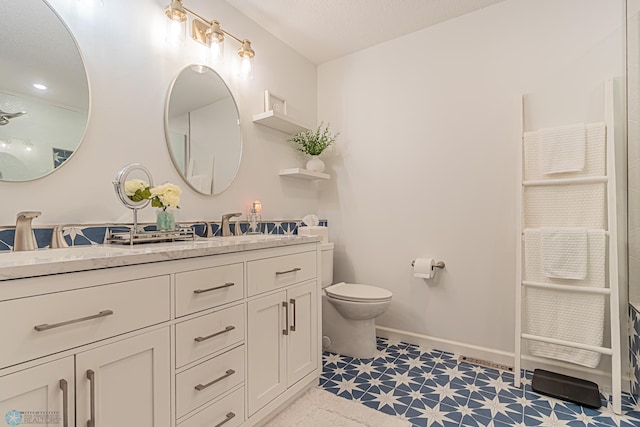 bathroom with vanity, toilet, and tile patterned floors