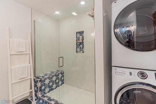 washroom with stacked washer / drying machine and a textured ceiling