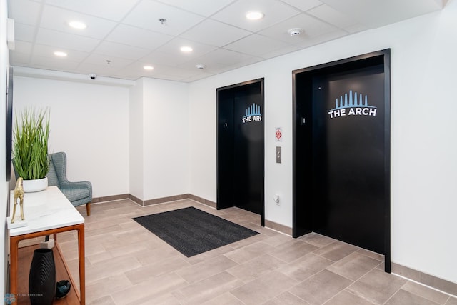 entrance foyer featuring a paneled ceiling and elevator