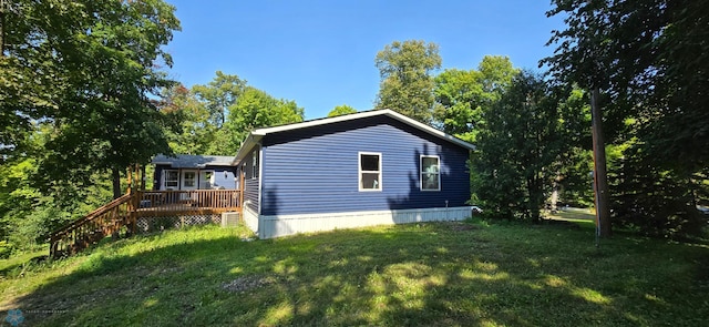 view of home's exterior with a yard and a wooden deck