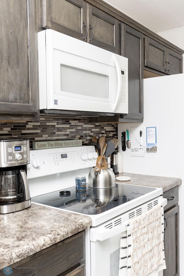 kitchen featuring dark brown cabinetry, backsplash, and white appliances