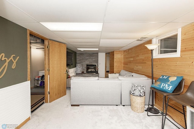 laundry area with light carpet, wood walls, a fireplace, and washing machine and dryer