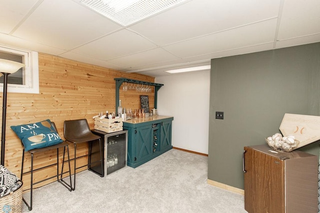 bar with wooden walls, light carpet, and a wood stove