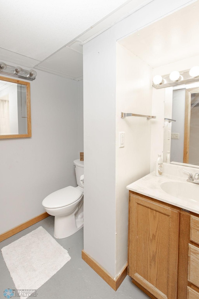 bathroom featuring vanity, toilet, and concrete flooring