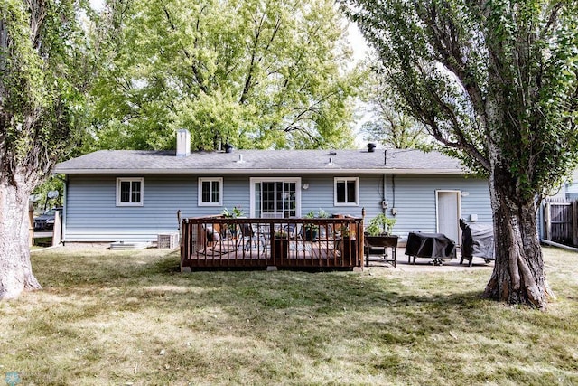 back of property with a deck and a yard