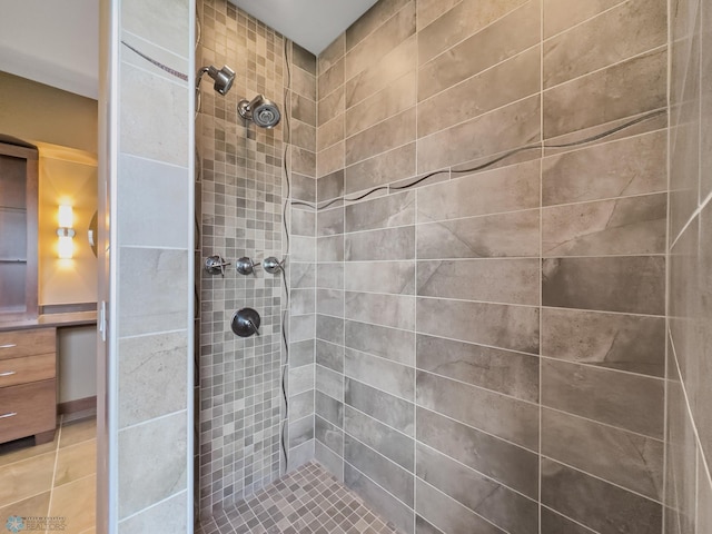 bathroom with a tile shower and tile patterned floors