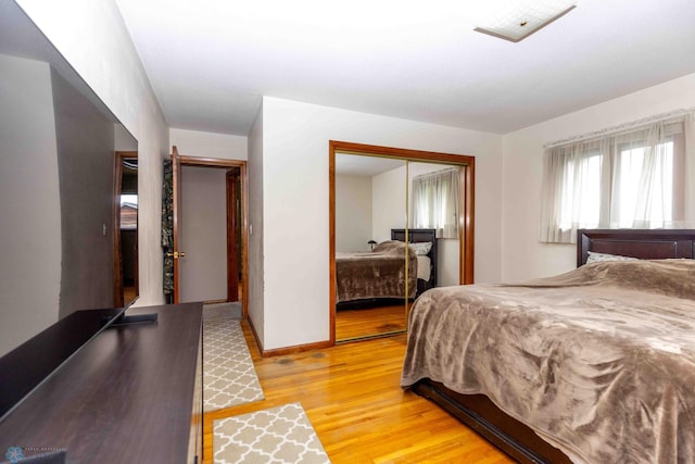 bedroom with light wood-type flooring and a closet