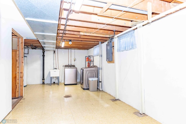 basement with electric panel, sink, and washing machine and clothes dryer