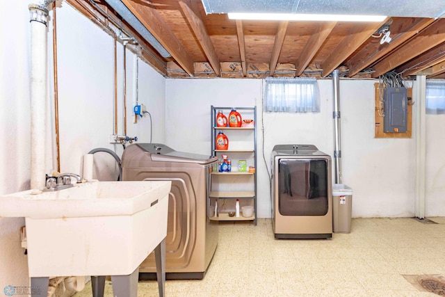 washroom with sink, electric panel, and washing machine and dryer