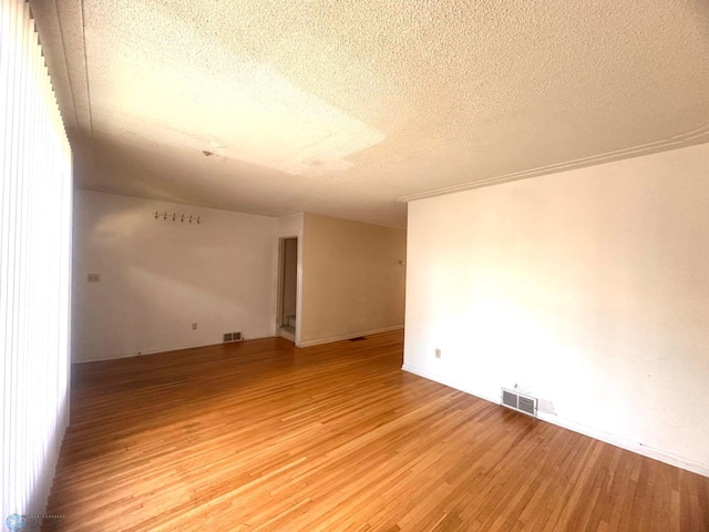 spare room featuring a textured ceiling and hardwood / wood-style floors