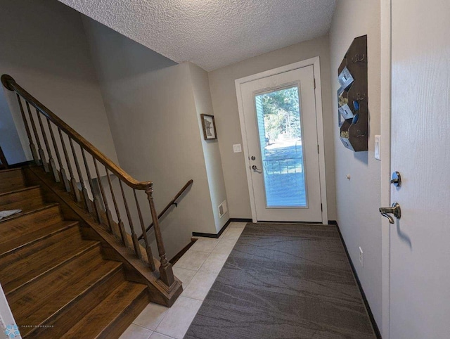 doorway featuring a textured ceiling and light tile patterned floors